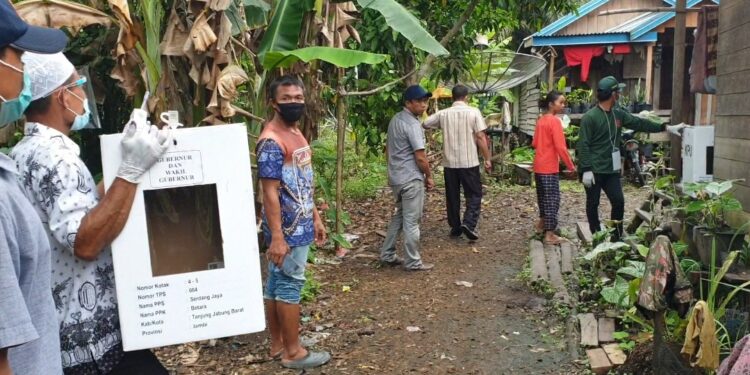 Pihak KPPS yang membawa kotak suara dan perlengkapan mencoblos mendatangi salah seorang rumah pemilih lansia di TPS 04 Desa Serdang Jaya