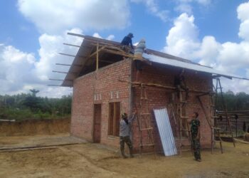 Di Bawah Terik Matahari, Satgas TMMD Pasang Atap Rumah Warga