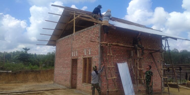 Di Bawah Terik Matahari, Satgas TMMD Pasang Atap Rumah Warga